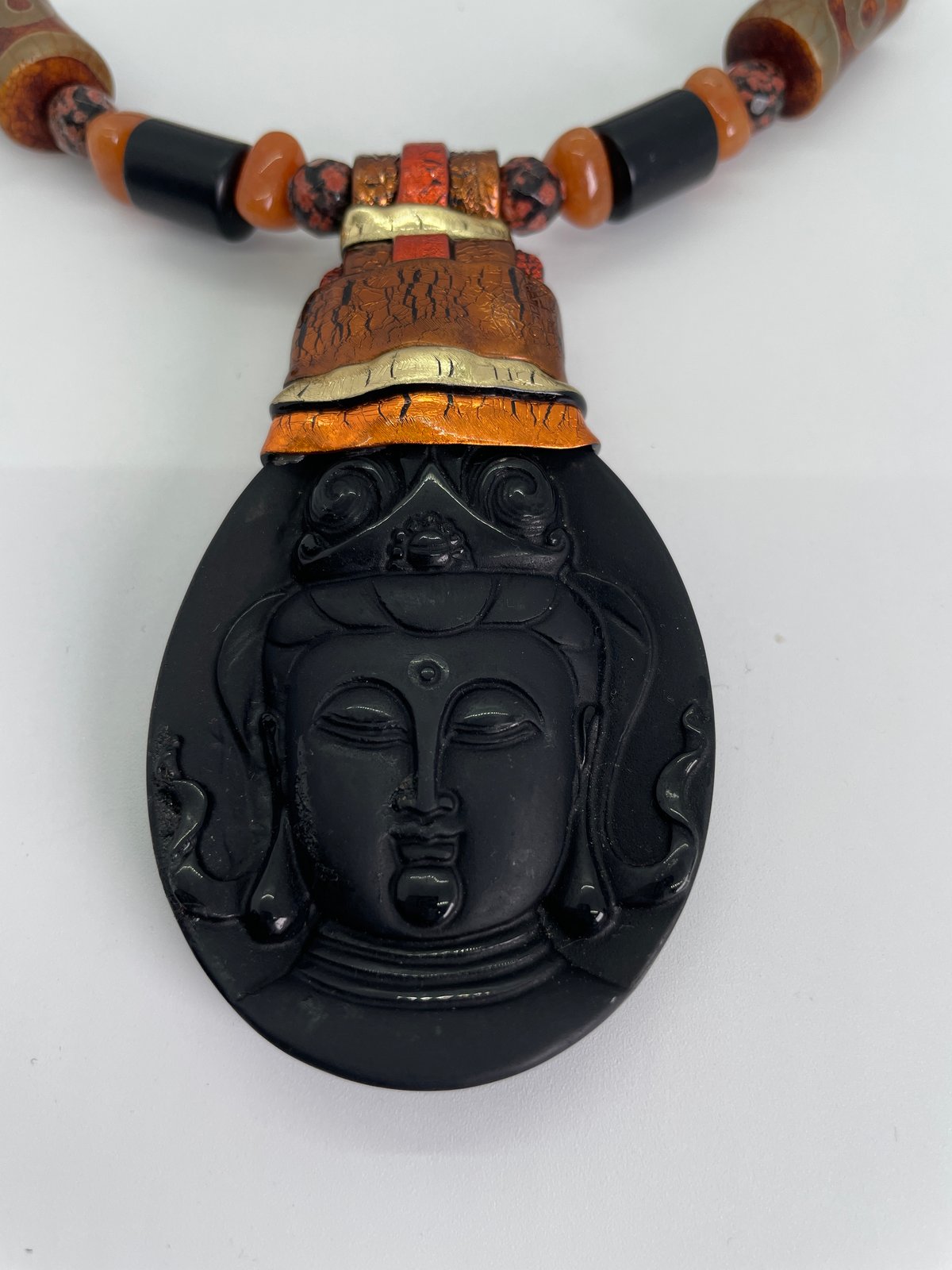Black Buddha face set in copper